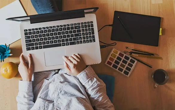 A person sitting on the floor with their laptop